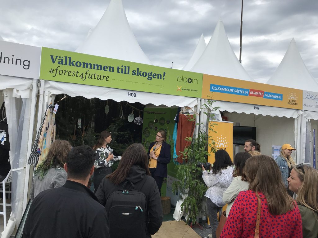 People listening to speakers in the bloom tent.