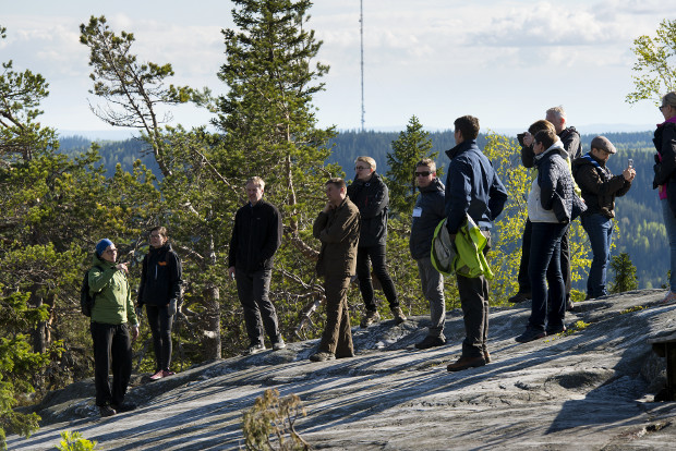 Forest academy participants on rocky forested hill.