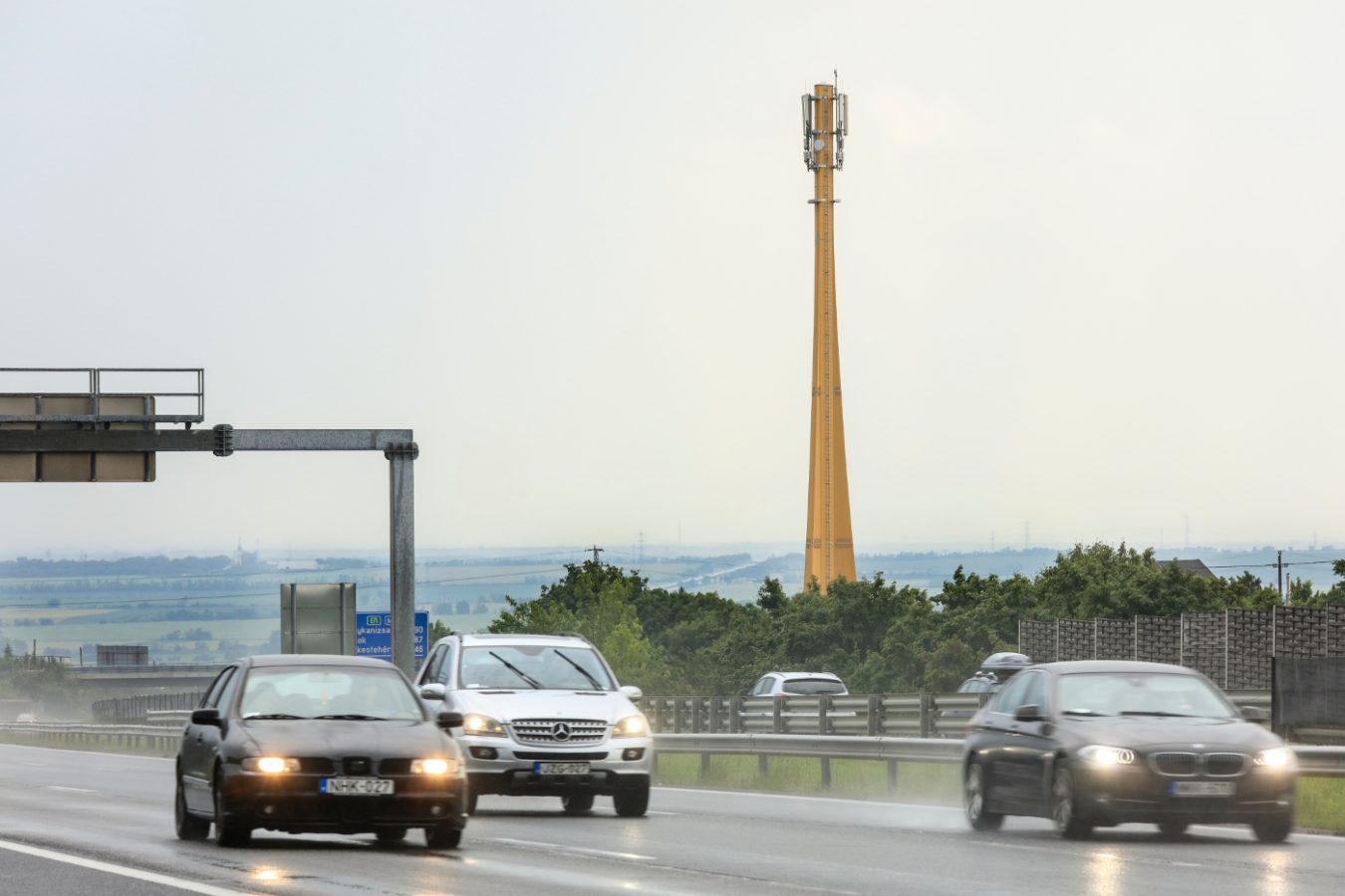 Traffic and in the background wooden telecommunication mast.