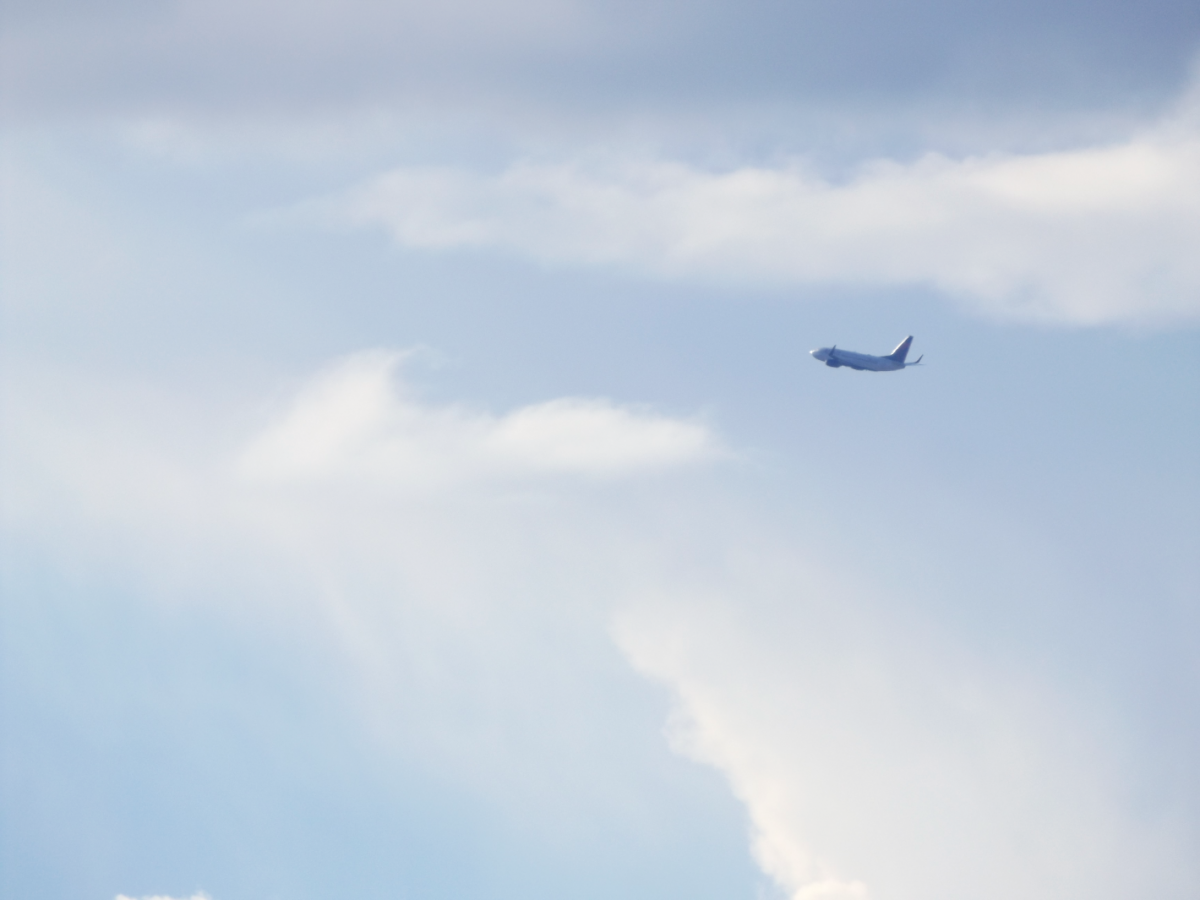 An airplane flying through the cloudy sky.