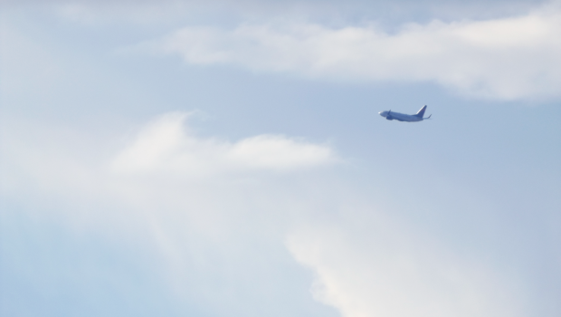 An airplane flying through the cloudy sky.