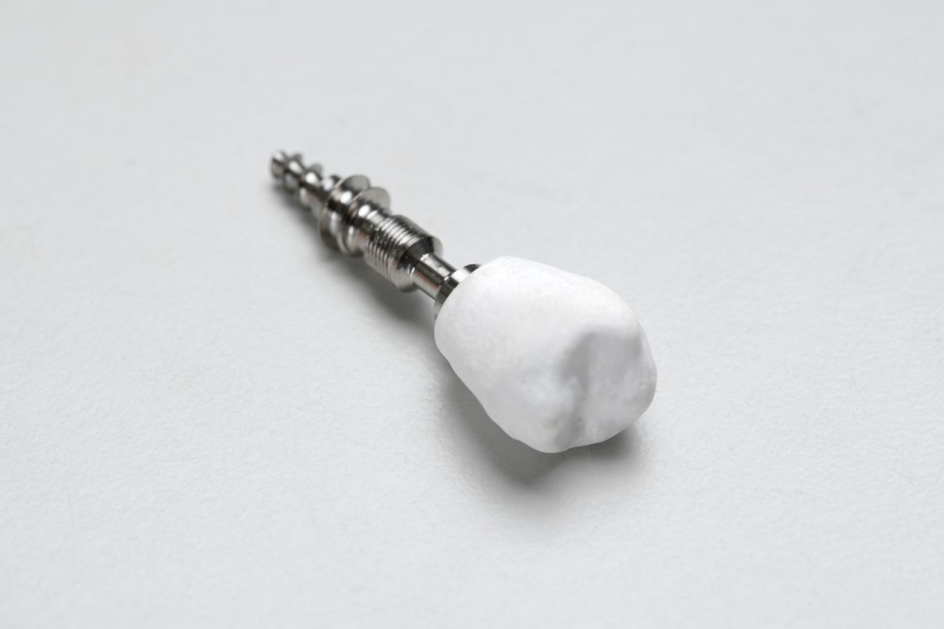 Nanokomposiitista valmistettu valkoinen hammaskruunu.
